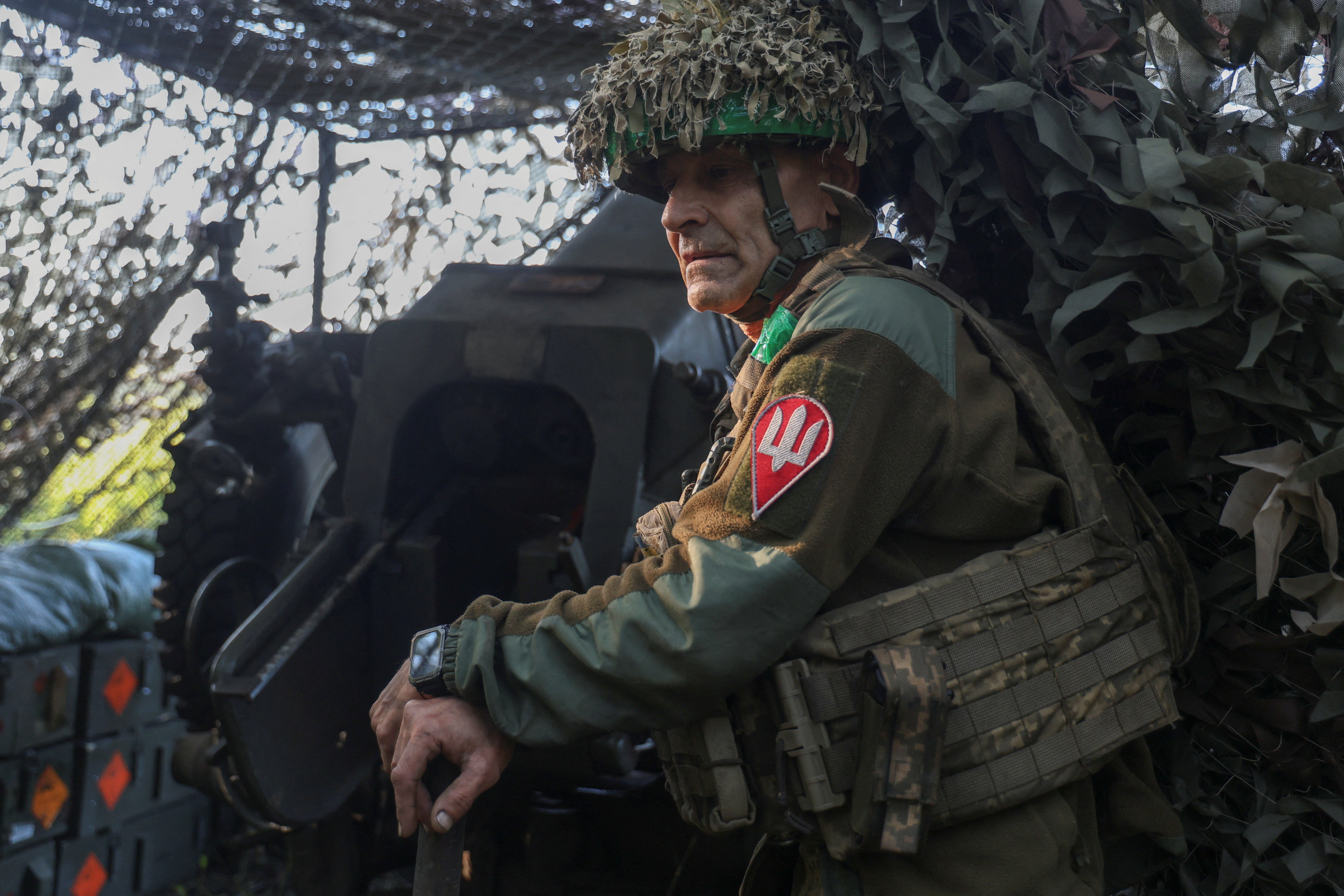 Ukrainian Armed Forces stands next to a D-30 howitzer during firing towards Russian troops, amid Russia's attack on Ukraine