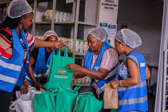 <p>A woman receives a food package from Food Banking Kenya, which has reported soaring demand in the wake of cuts to USAID</p>