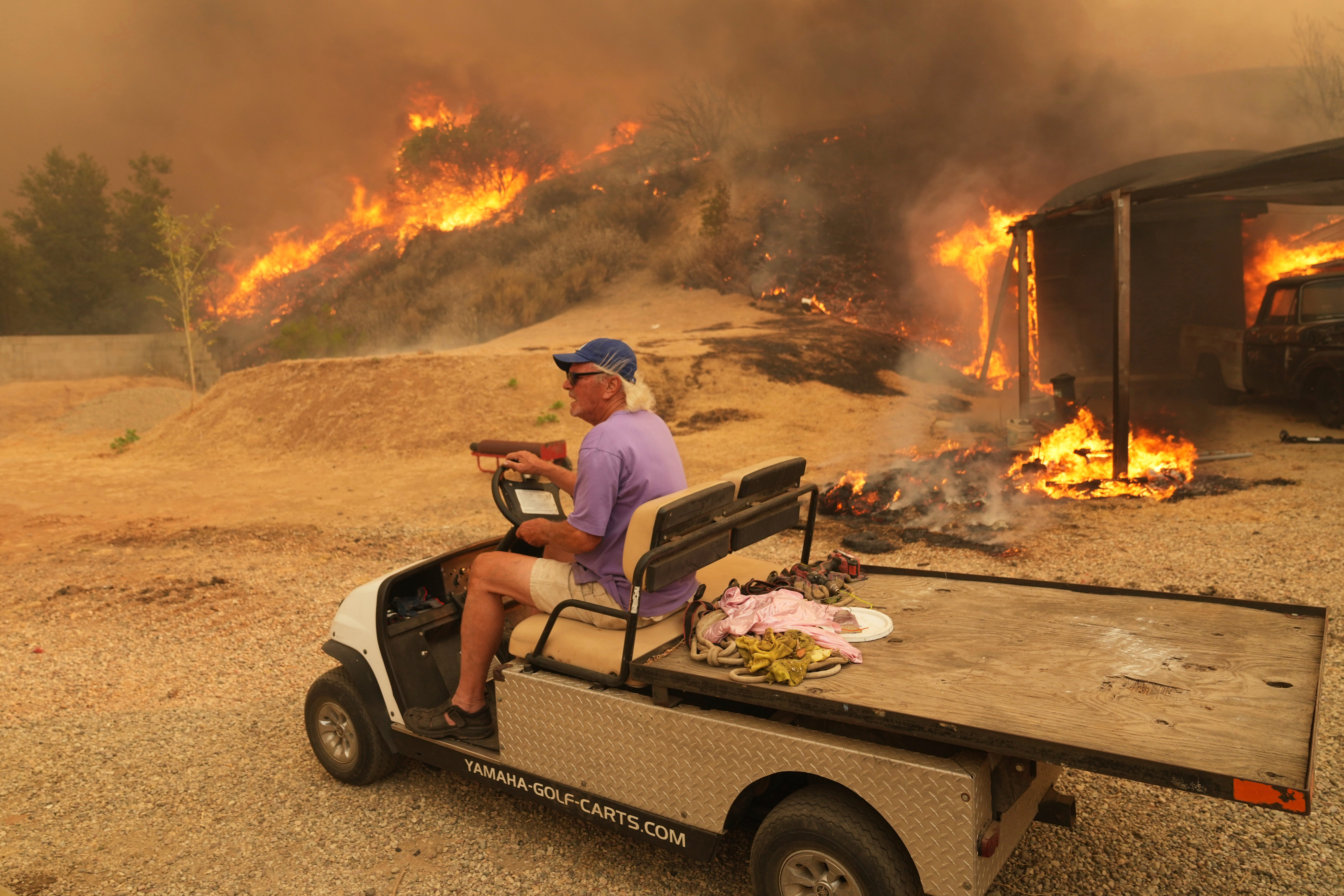 A resident was pictured fleeing the fire on a golf buggy. Evacuation orders are in place in the area.