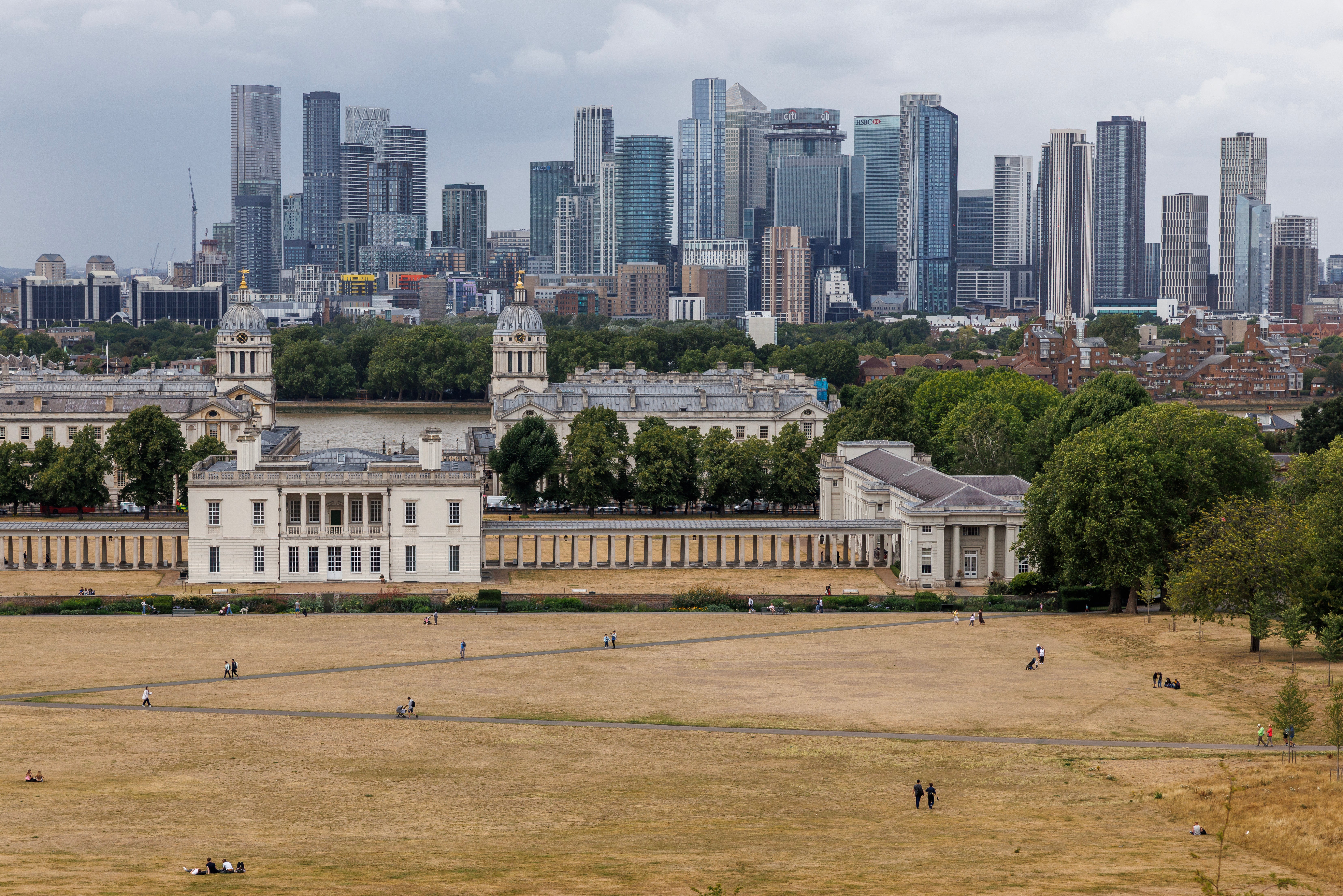 People walk through dry grass on July 15, 2025 at Greenwich Park in London, England.