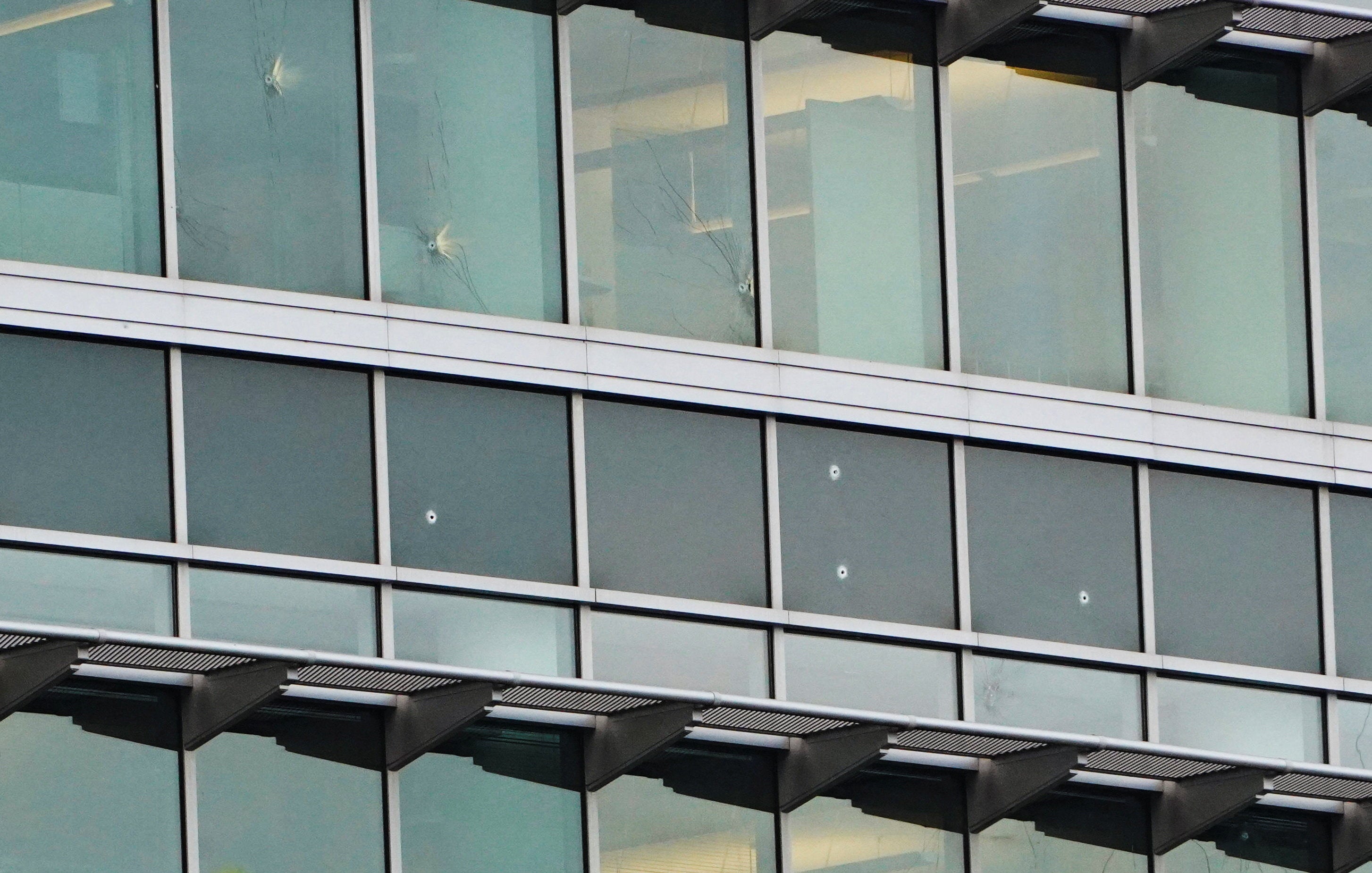 Windows on a CDC building pockmarked by bullet holes. The gunman struck at least four CDC buildings and killed a DeKalb County police officer, officials said