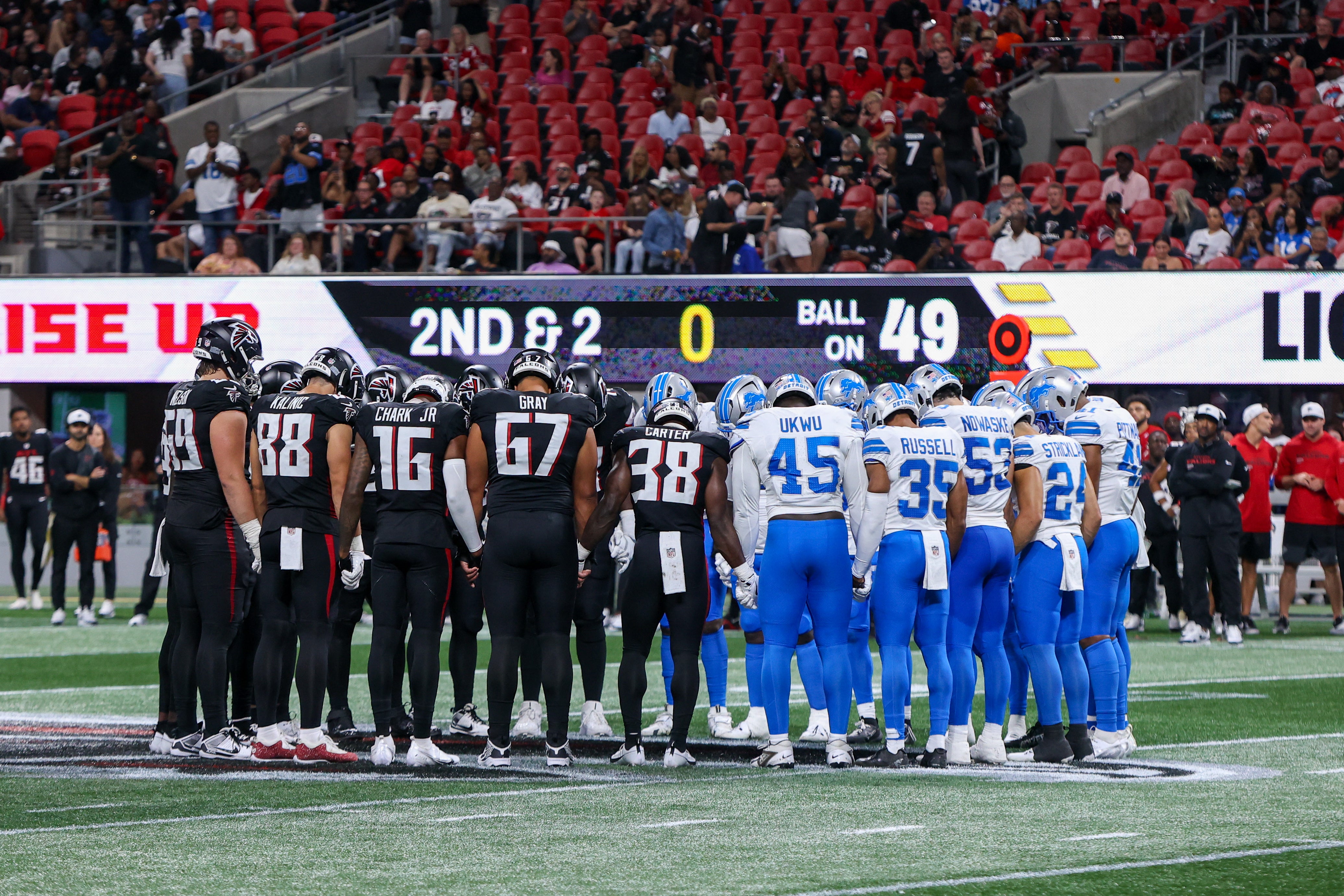 Os jogadores de Atlanta Falcons e Detroit Lions oram após a lesão