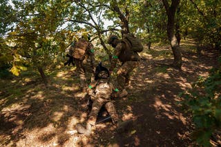Ukrainian National Guard servicemen carry their comrade on stretcher during a training not far from the frontline on Pokrovsk direction on Friday