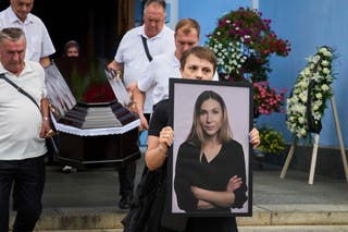 A colleague carries a portrait of Victoria Roshchyna during her funeral at the St. Michael Monastery in Kyiv
