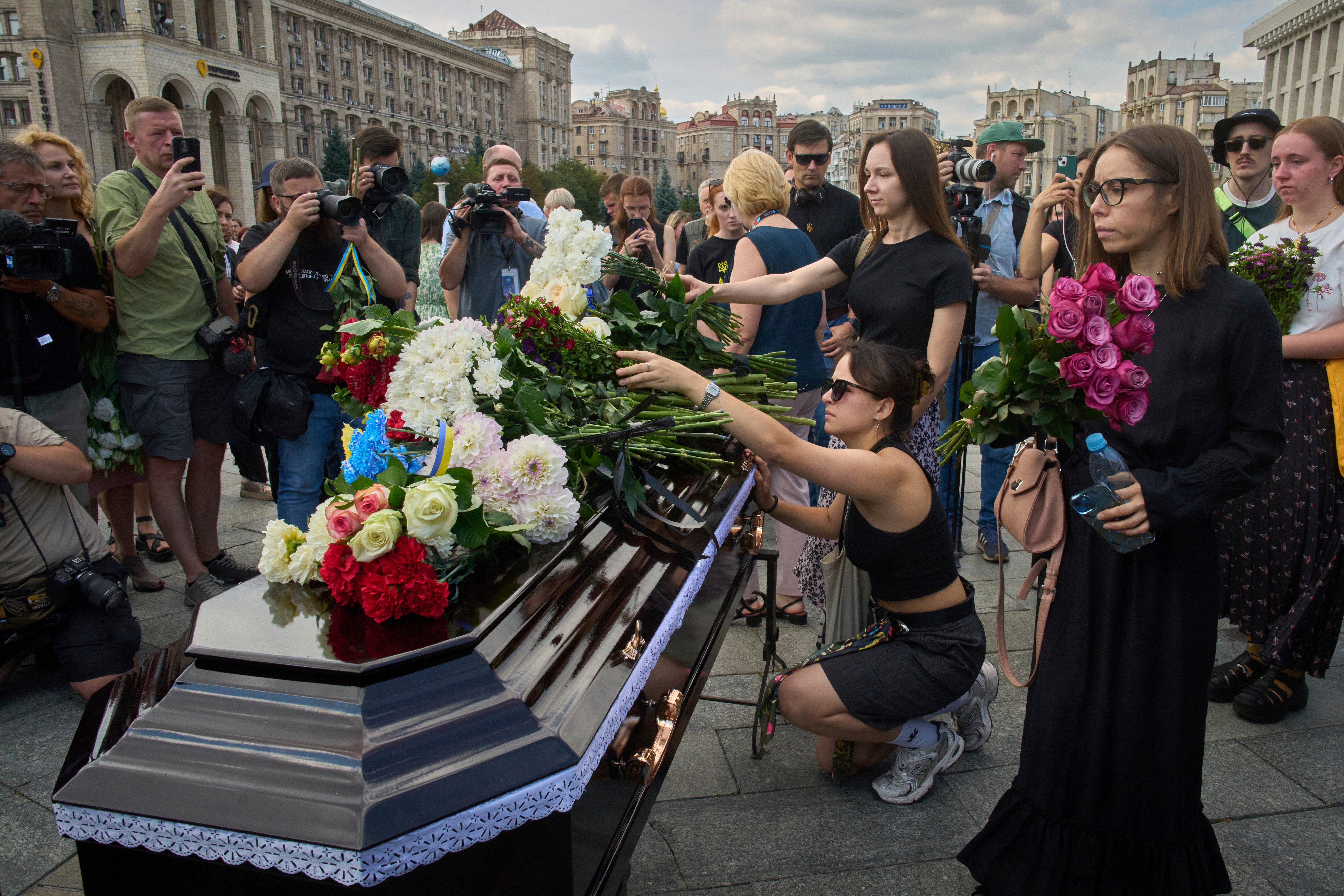 Meslektaşları ve arkadaşları, Cuma günü Kiev'in merkezindeki Bağımsızlık Meydanı'ndaki cenaze töreninde Victoria's Coffin Roshchyna'ya çiçek atıyor