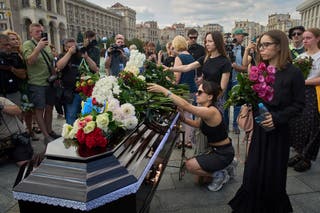 Colleagues and friends lay flowers on the coffin of Victoria Roshchyna during the funeral ceremony in the Independence square in central Kyiv on Friday
