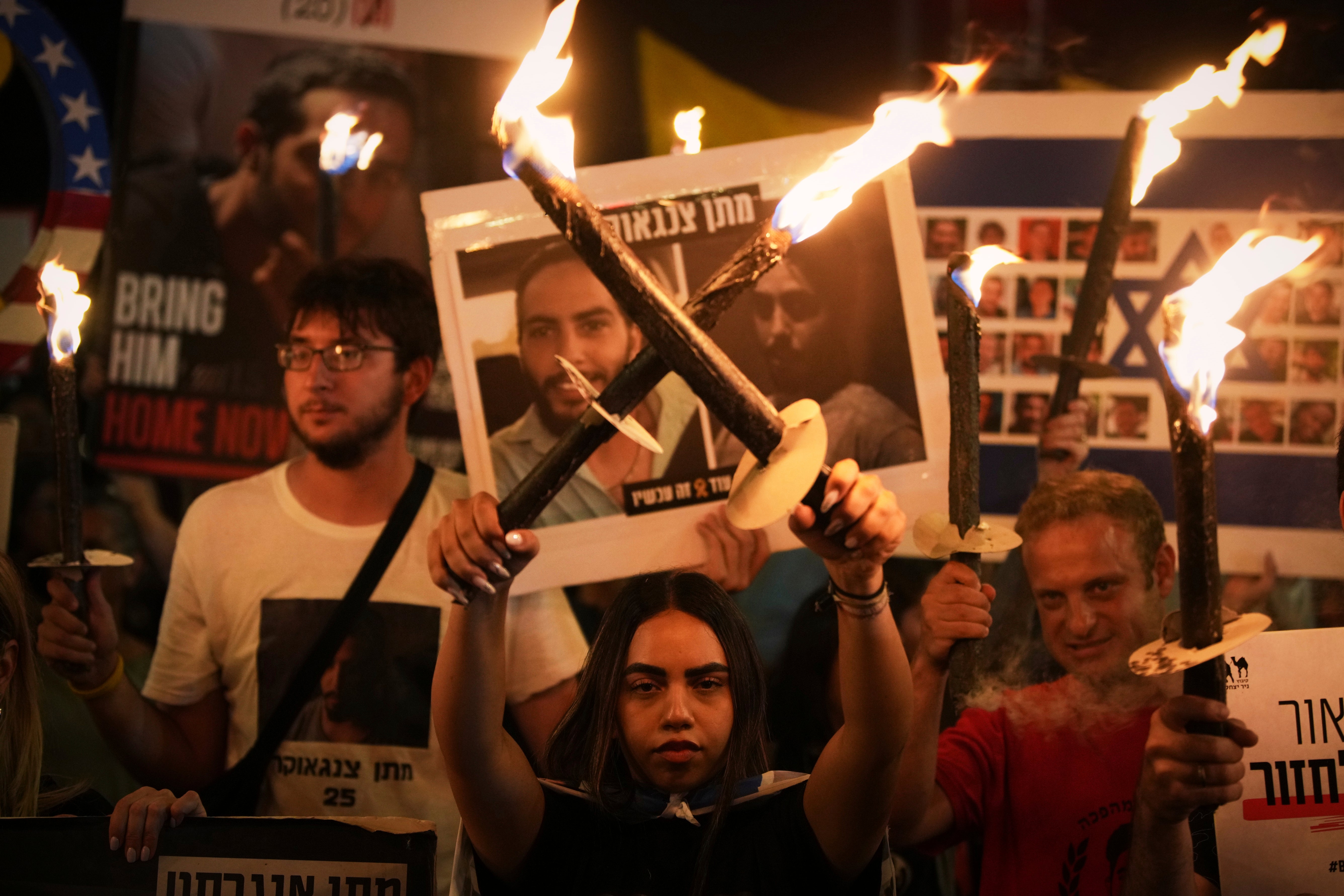 Demonstrators light torches during a protest demanding the immediate release of all hostages from Hamas captivity in the Gaza Strip and calling for an end to the war, outside the prime minister’s office in Jerusalem, Thursday, Aug 7