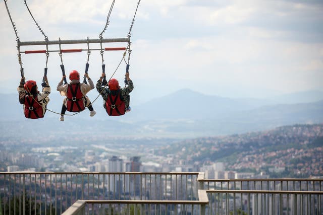 <p>Tourists enjoy a giant swing overlooking the city on Trebevic mountain near Sarajevo, Bosnia, Tuesday, Aug. 5, 2025. (AP Photo/Armin Durgut)</p>