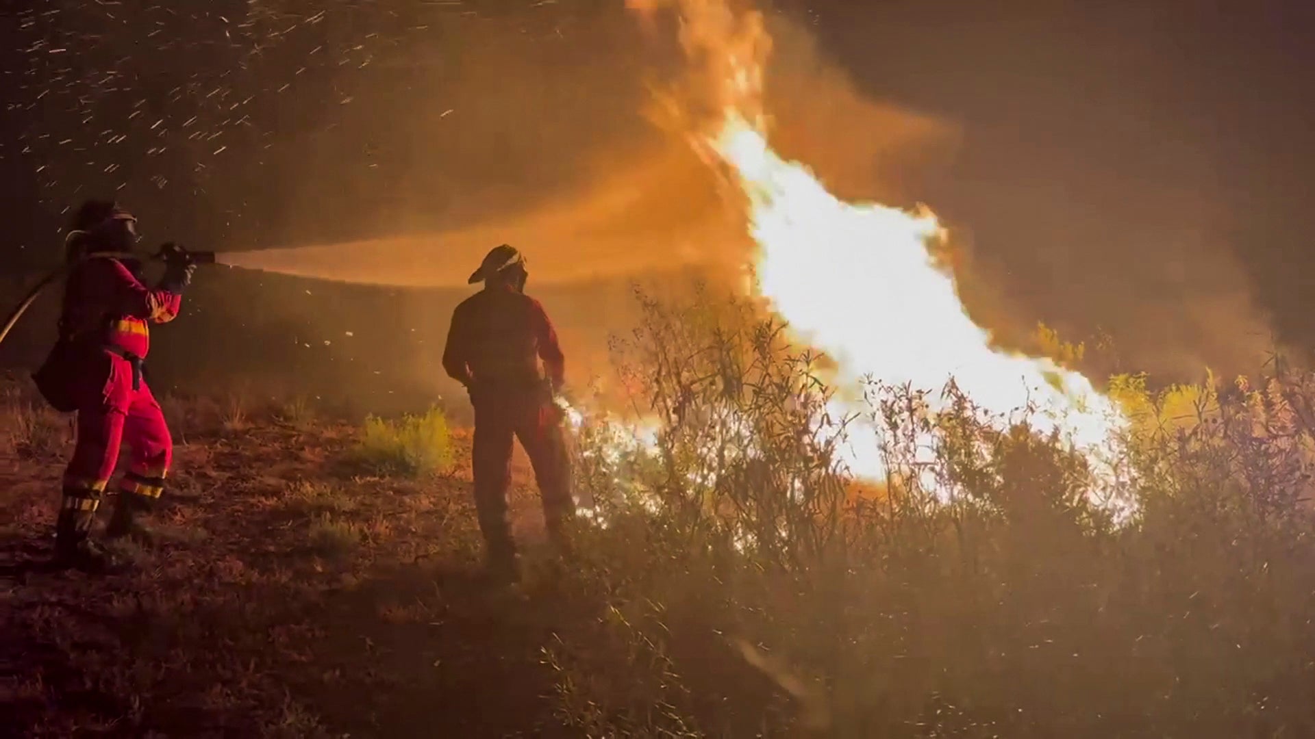 This video-grab taken from handout footage released by Spain's Emergency Military Unit (UME) on August 11, 2025, shows military firefighters tackling a wildfifre near Carucedo, northwestern Spain.