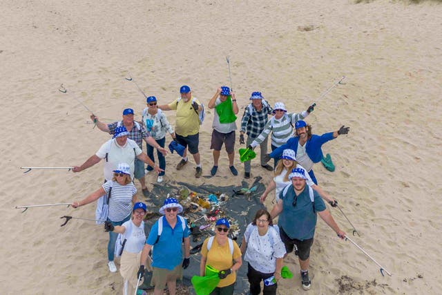 National Lottery winners joined together to help clean up at popular Bamburgh beach in Northumberland (Anthony Devlin/National Lottery/PA)