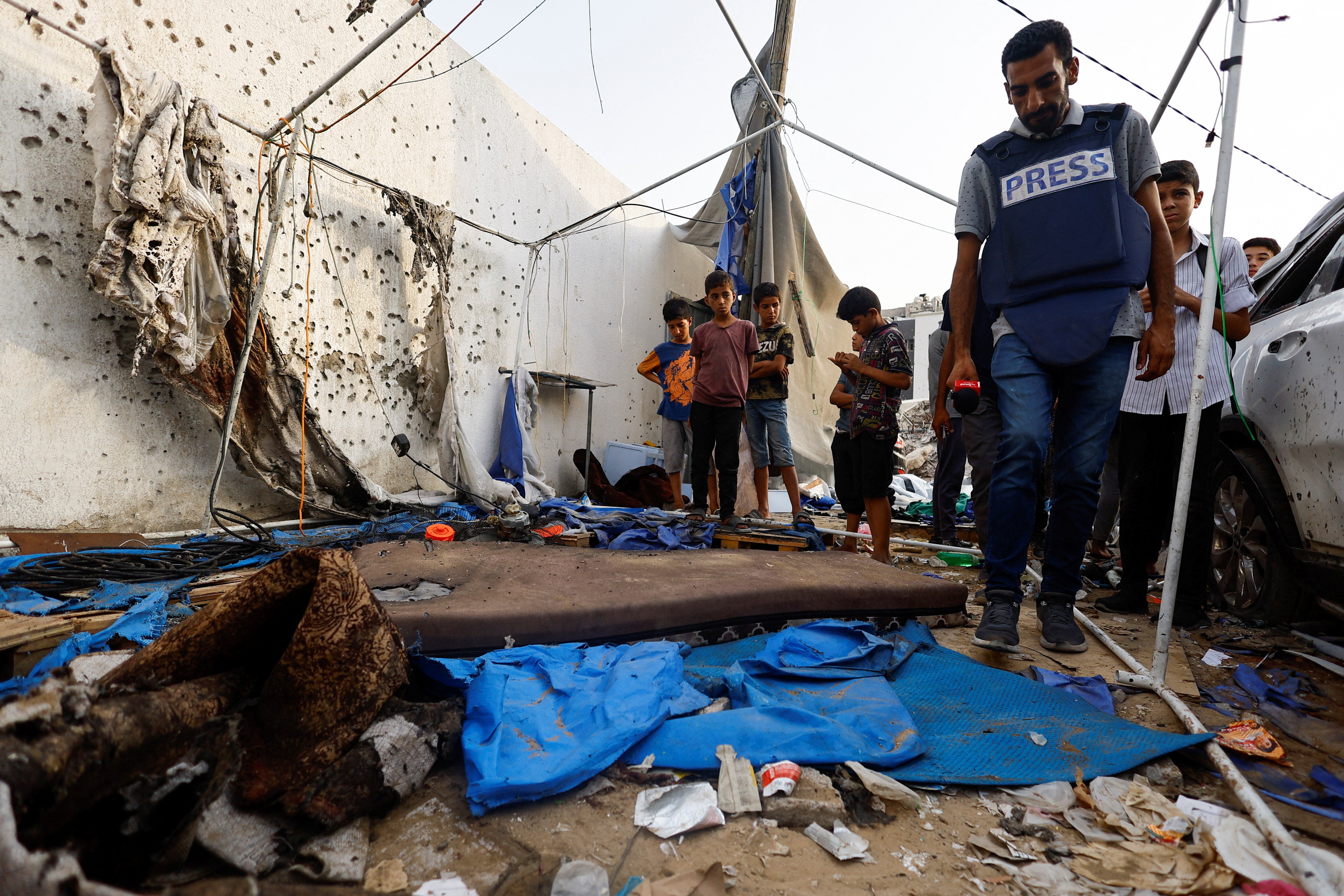 A member of the media inspects the damage at the site of an Israeli strike on a tent near Shifa Hospital where Al Jazeera journalists Anas Al Sharif, Mohammed Qreiqeh, Ibrahim Zaher, and Mohammed Noufal were killed, in Gaza City August 11, 2025