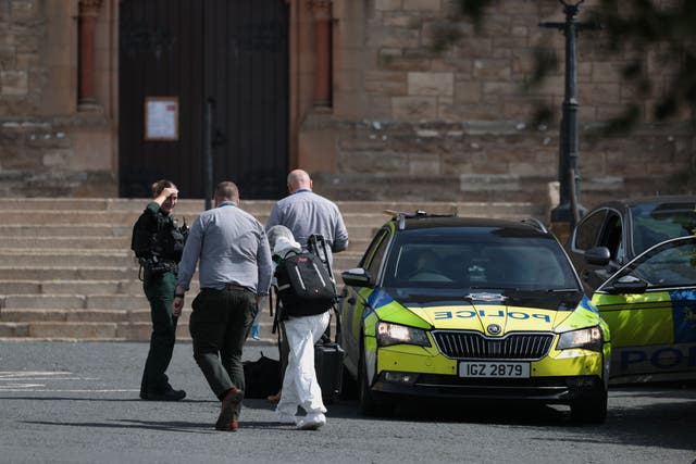 <p>Police Service of Northern Ireland officers and a scenes of crime officer outside St Patrick’s Church in Downpatrick</p>