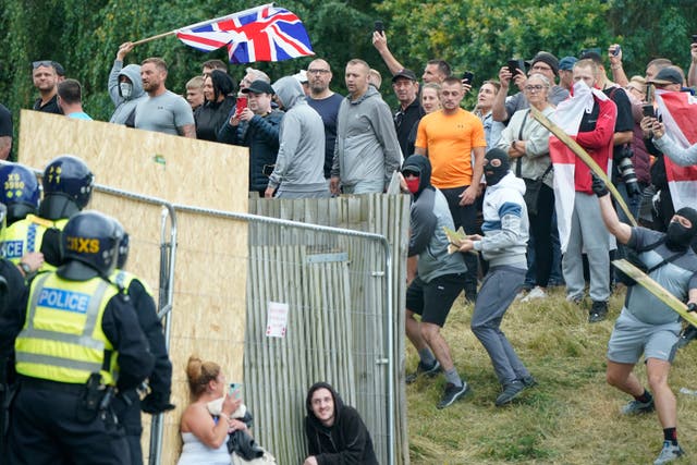 <p>Scott McGuire (bright orange t-shirt) and his brother were jailed for their roles in a riot outside a hotel in August 2024</p>