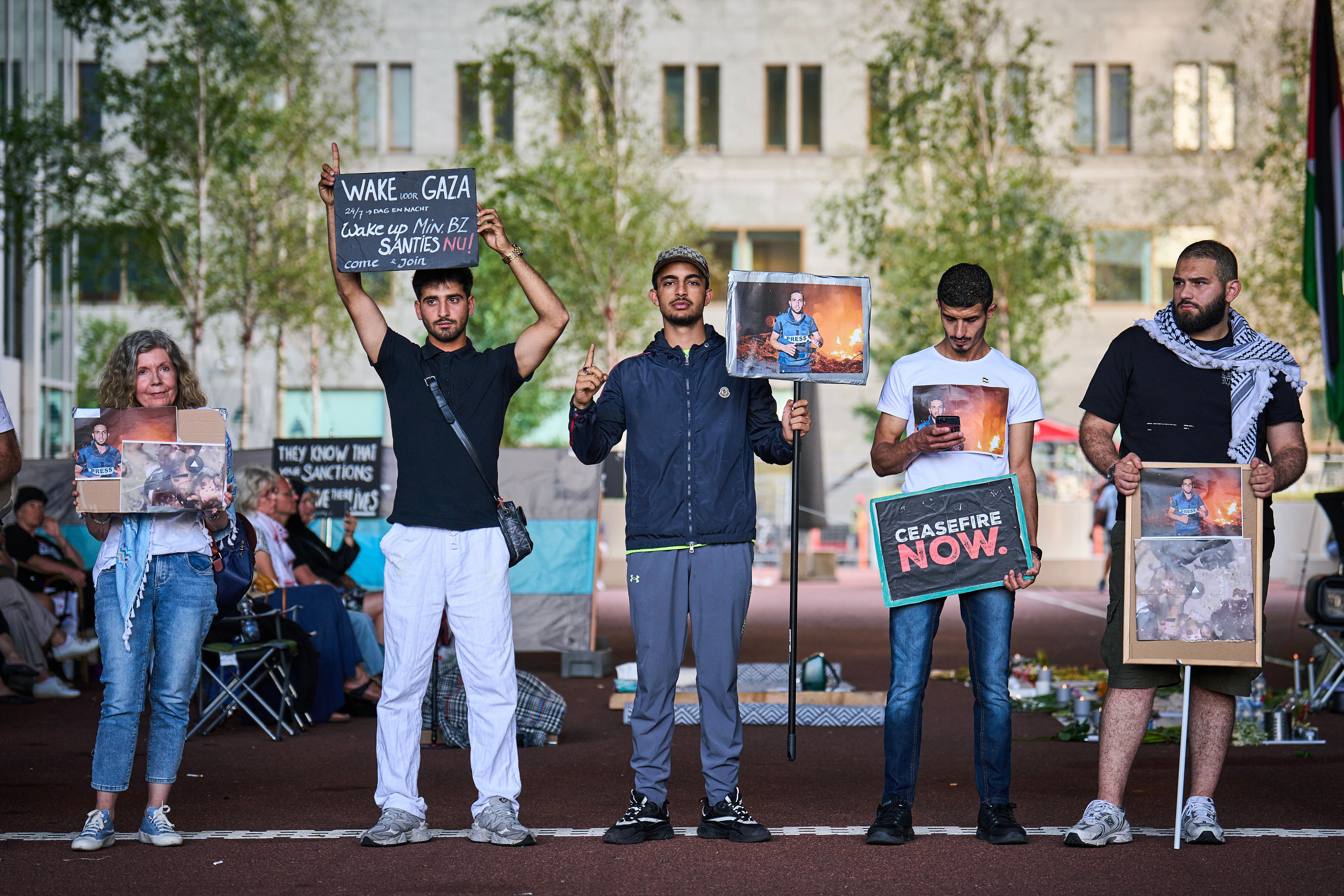 Demonstrators hold placards depicting portraits of the late Palestinian journalist Anas Al-Sharif as they gather for a vigil to commemorate all journalists killed in Gaza, at the Ministry of Foreign Affairs in The Hague, on August 11, 2025.