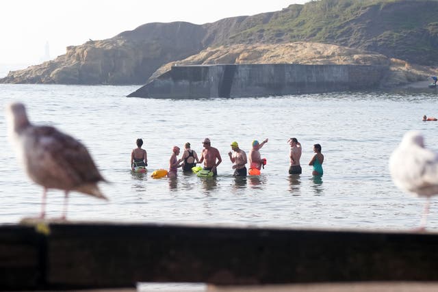 People swimming at Cullercoats Bay in North Tyneside on Tuesday (Owen Humphreys/PA)