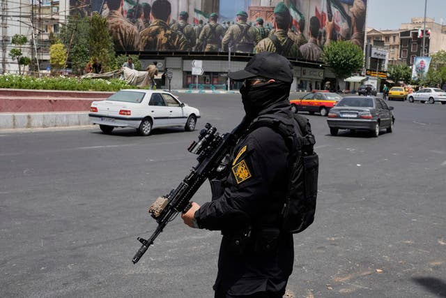<p>A member of Iran's Revolutionary Guard stands guard at Enqelab-e-Eslami (Islamic Revolution) square in downtown Tehran, Iran, Tuesday, June 24, 2025</p>