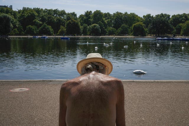 <p>A man sits in the sun at a park in London as  face a heat wave Monday, Aug. 11, 2025</p>