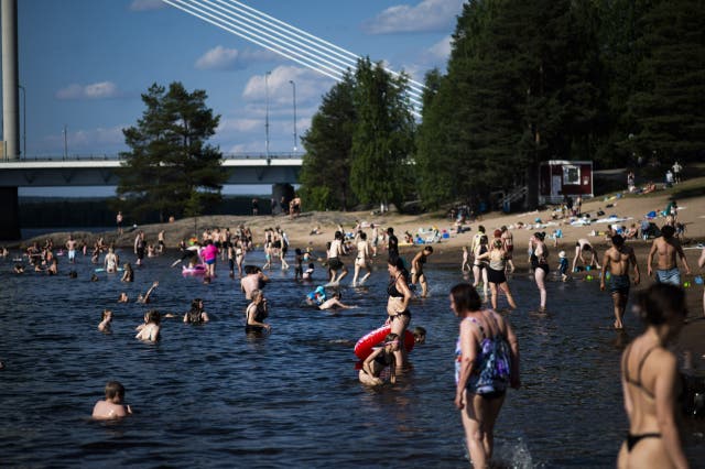 <p>People bathing at the Ounaskoski Beach at the Arctic Circle in Rovaniemi, Finnish Lapland</p>