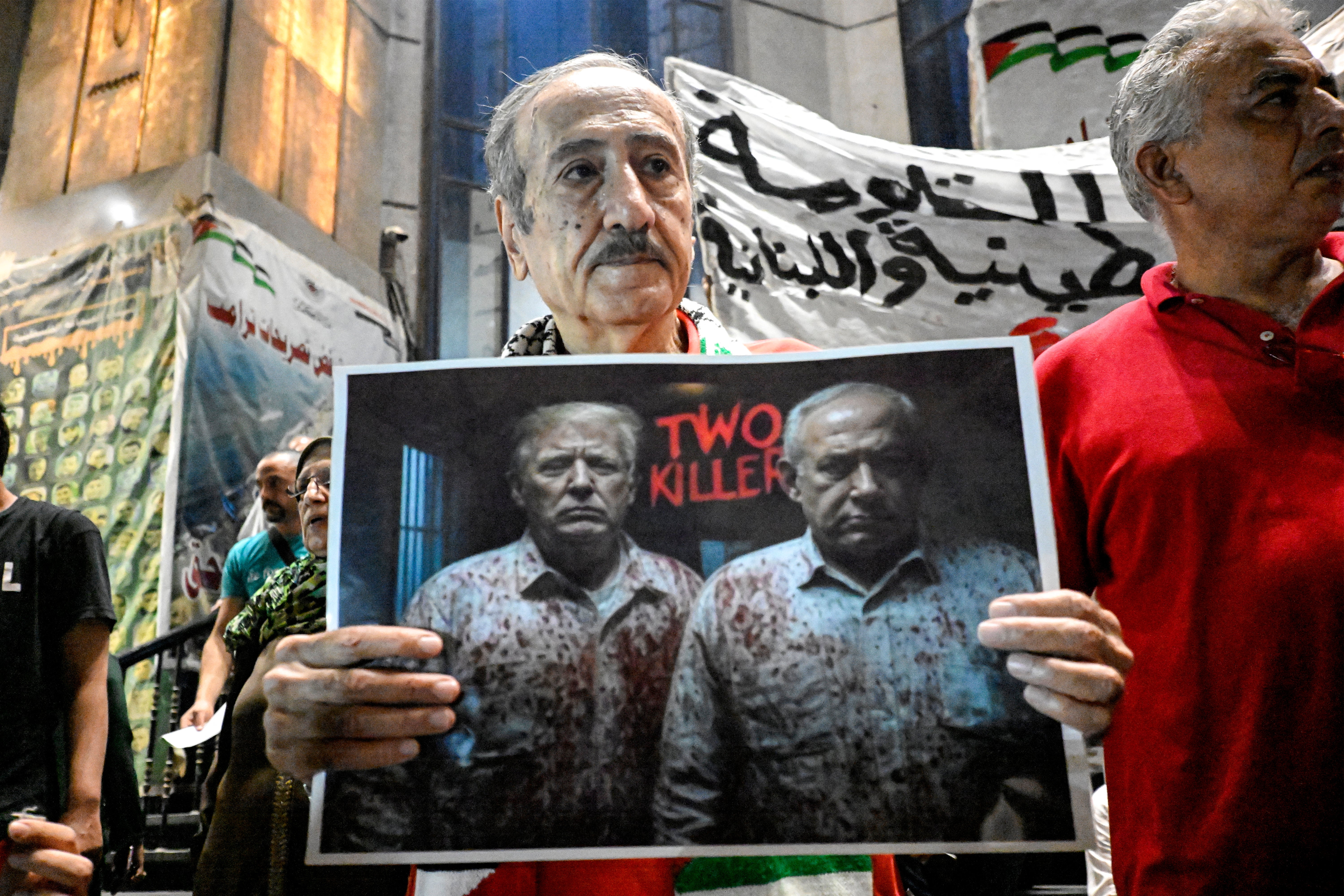 A demonstrator holds a sign critical of President Donald Trump and Israeli Prime Minister Benjamin Netanyahu
