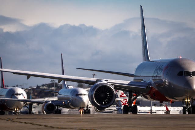 <p>A Jetstar Boeing 787-8 plane (R) and a Qantas Boeing 737-800 plane (C) line up at Sydney International Airport</p>