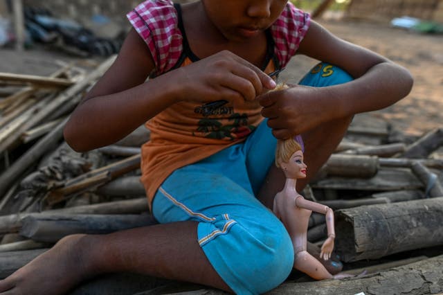 <p>This photo taken on 11 January 2021 shows a Chin child playing with a doll in Bethel village in Hmawbi, on the outskirts of Yangon, where hundreds of members of the Chin ethnic community have settled after being displaced by fighting between Myanmar's military and the Arakan Army in the country's north</p>