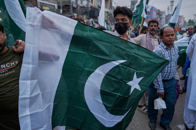 <p>A vendor displays a Pakistani flag to customers in Lahore, Pakistan</p>