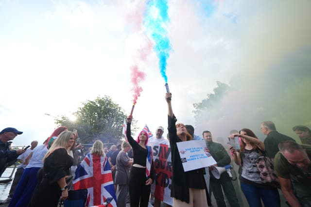 <p>Protesters outside the Bell Hotel in Epping, Essex, which has been ordered to close</p>
