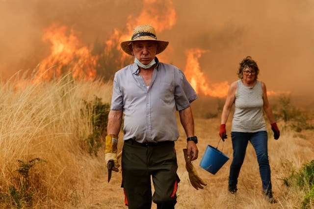 <p>Local residents react in front of the fire during a wildfire in Santa Baia De Montes, northwestern Spain, Thursday, Aug. 14, 2025</p>