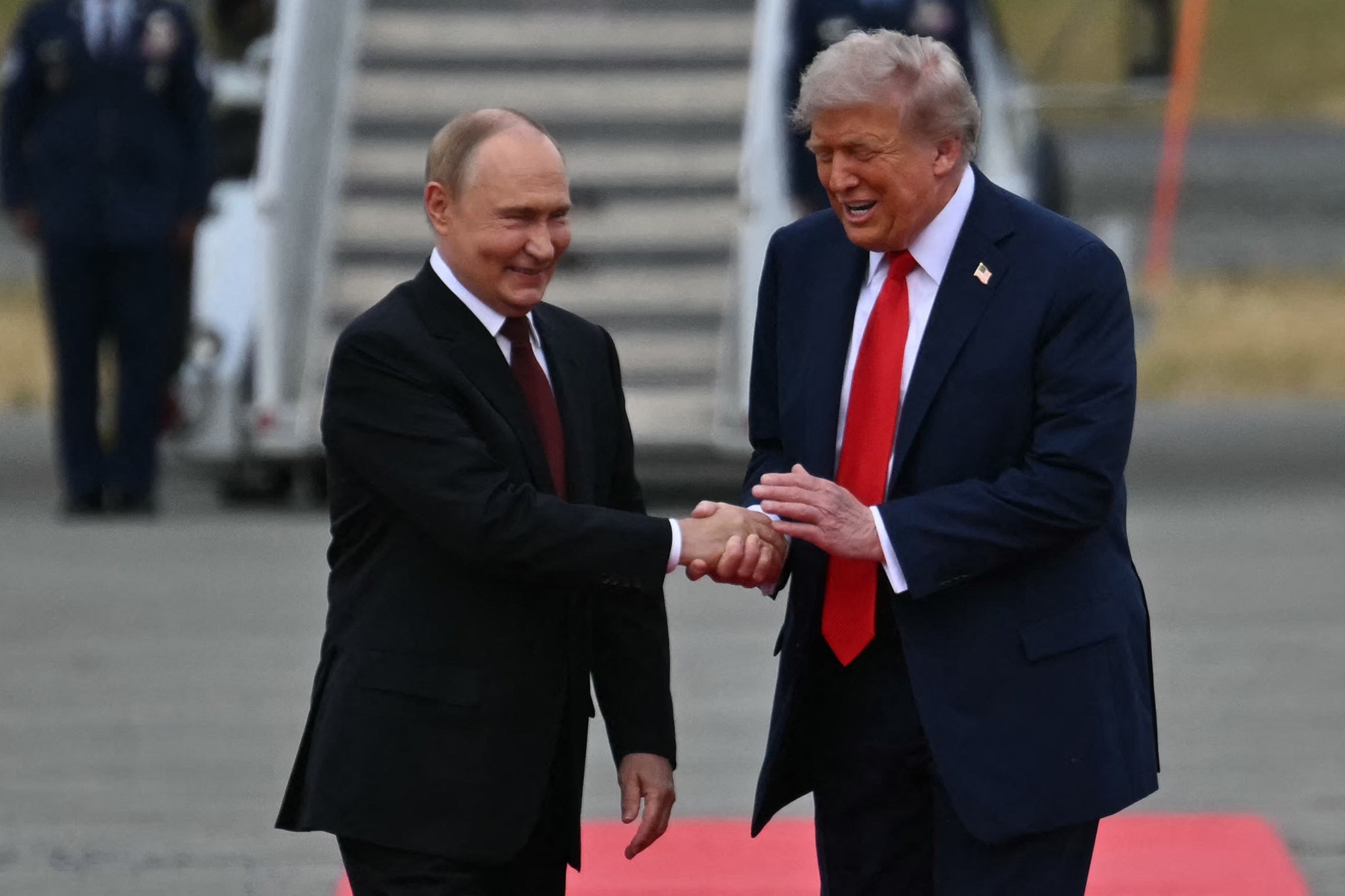 Trump and Putin laugh as they greet each other