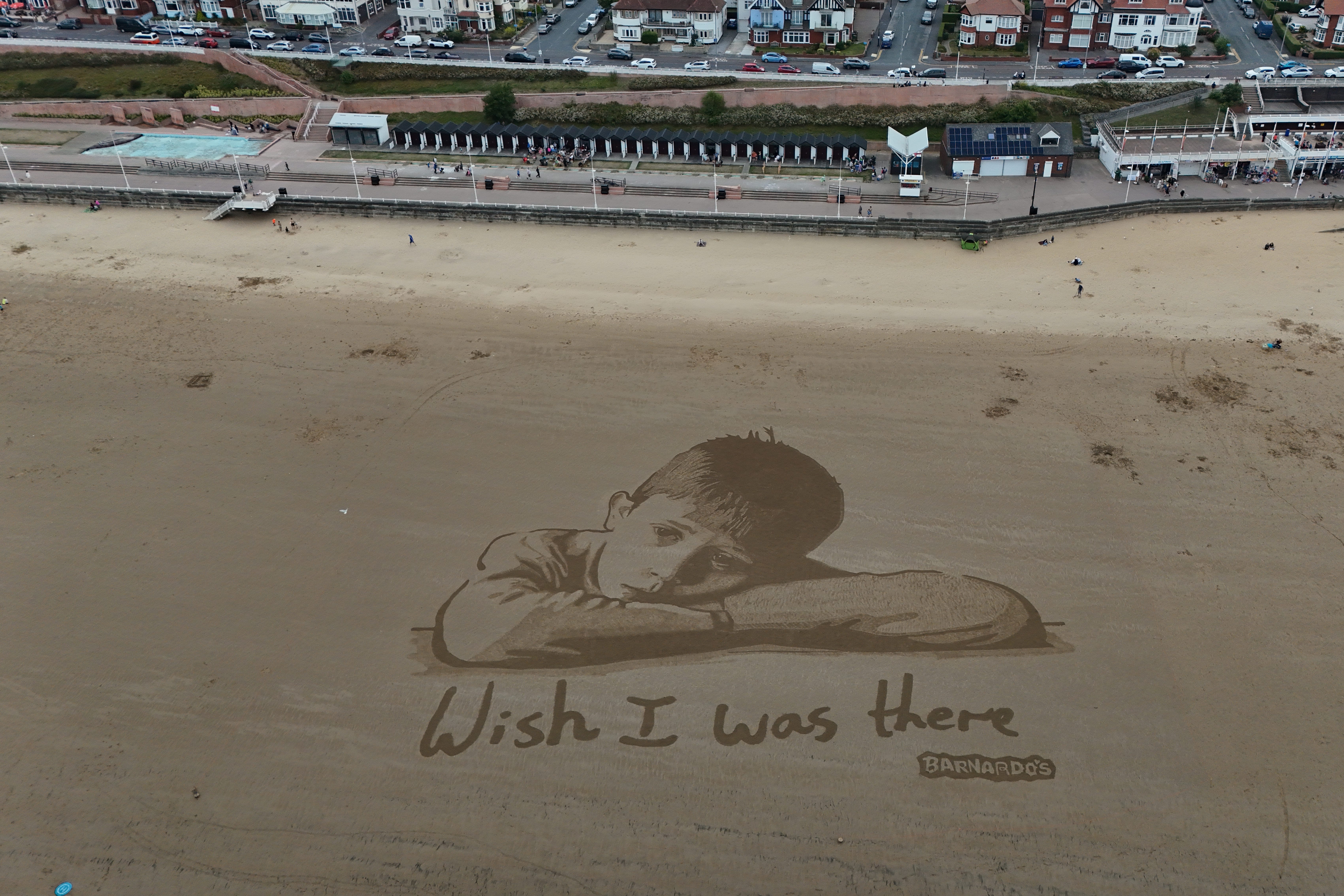 The giant sand portrait was commissioned to highlight how millions of children in the UK are missing out on days out, Barnardo’s said (Richard McCarthy/PA)