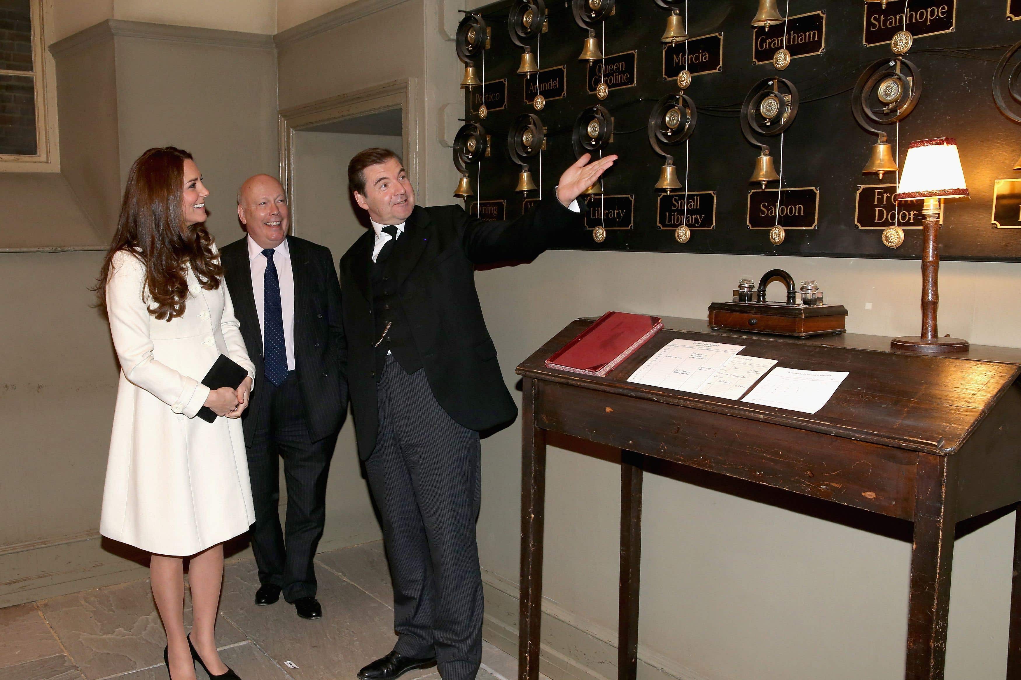The then-Duchess of Cambridge is shown the Downton Abbey servants bells by actor Brendan Coyle and the series’ creator Lord Fellowes during an official visit to the set at Ealing Studios in 2015 (PA)