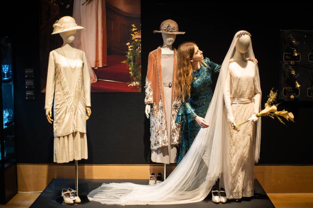 A member of gallery staff adjusts Lady Mary’s wedding dress worn in Downton Abbey by actress Michelle Dockery (James Manning/PA)