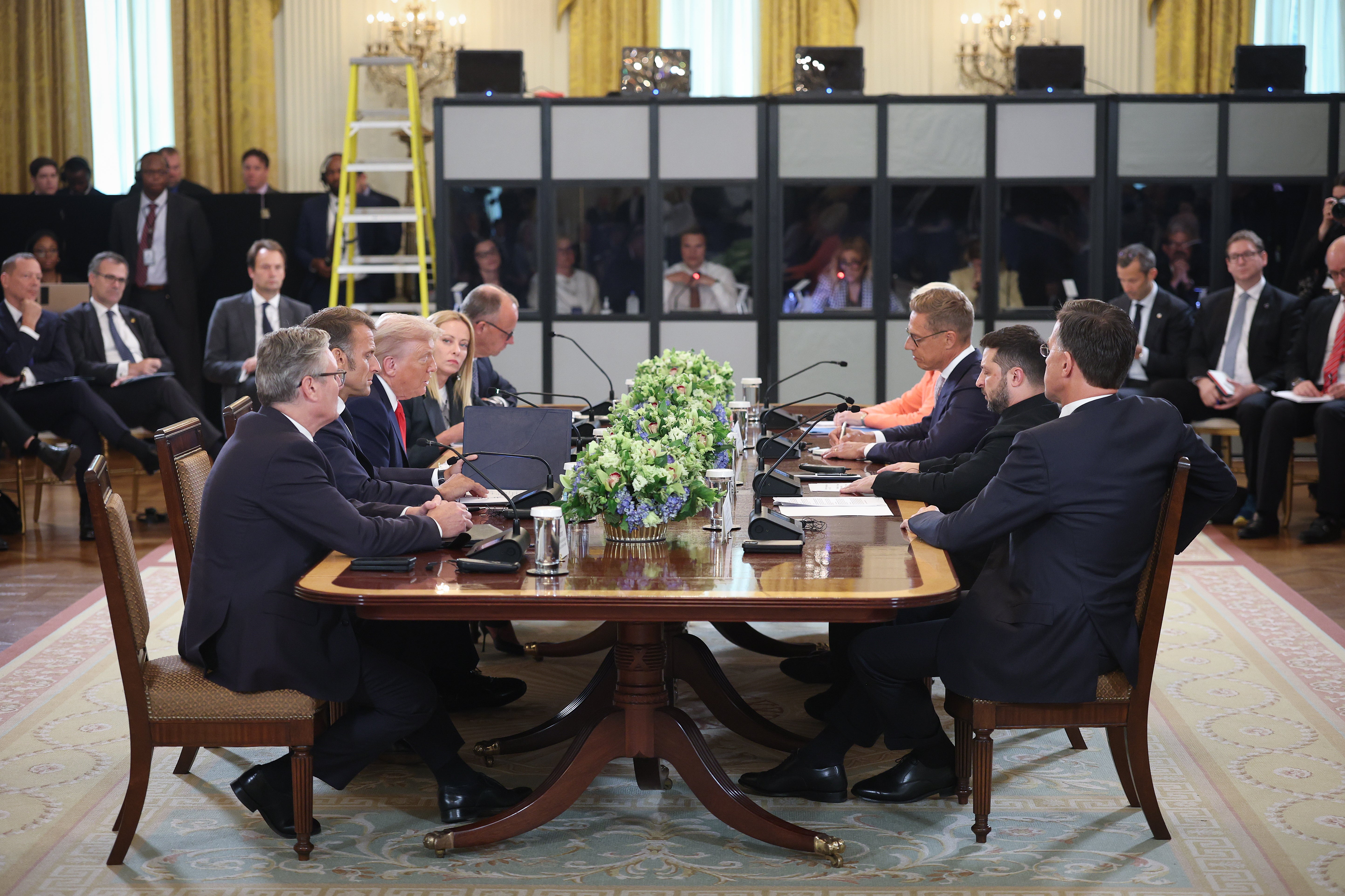 President Donald Trump sits across the table from Ukrainian President Volodymyr Zelensky, and European leaders during the meeting