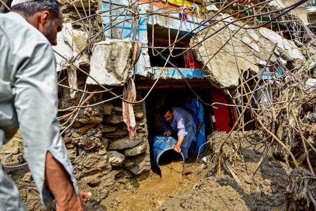 <p>A resident removes sludge from his damaged house a day after flash floods in Buner district of Khyber Pakhtunkhwa province, Pakistan, on 16 August 2025</p>