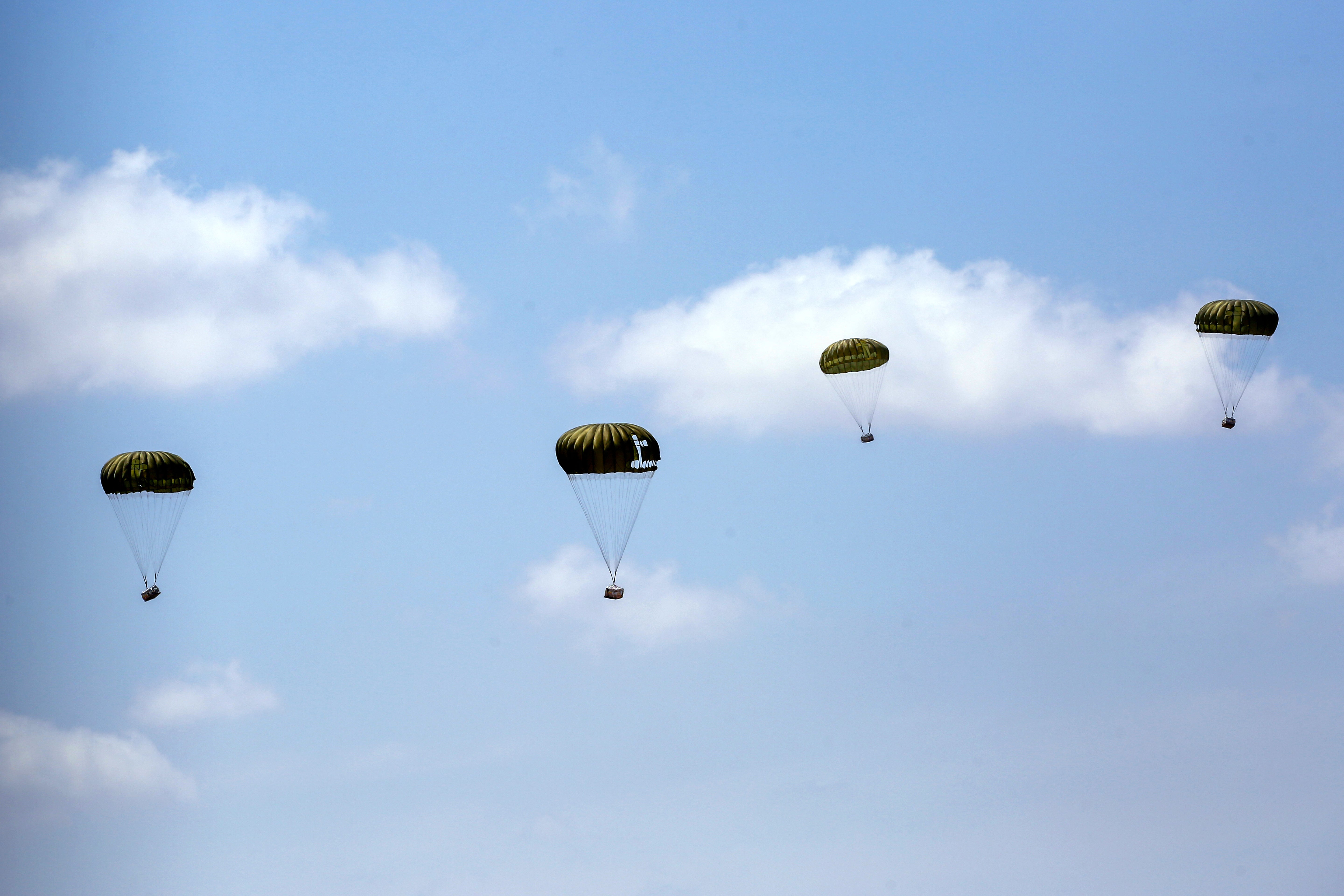 Picture taken from the Bureij camp for displaced Palestinians in the central Gaza Strip shows parcels of humanitarian aid being airdropped on 17 August 2025