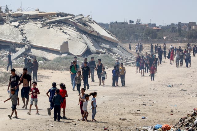 <p>Displaced Palestinians make their way towards a humanitarian aid airdrop at the Bureij camp in central Gaza Strip on 17 August 2025</p>