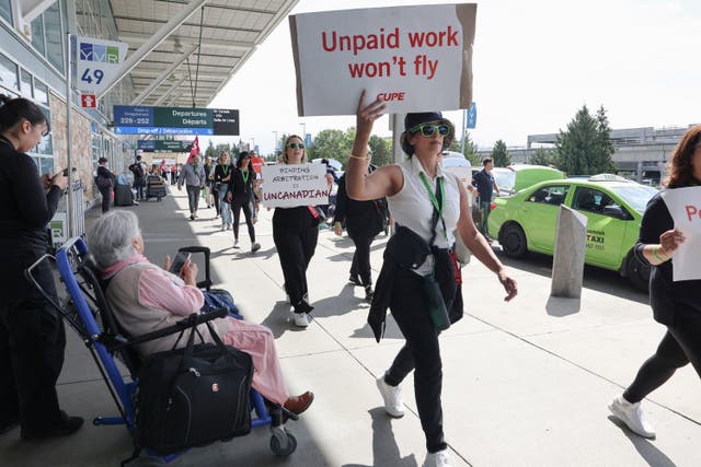 <p>A passenger watches as picketing Air Canada flight attendants remained on strike past the deadline in a government-backed labour board's order to return to work</p>