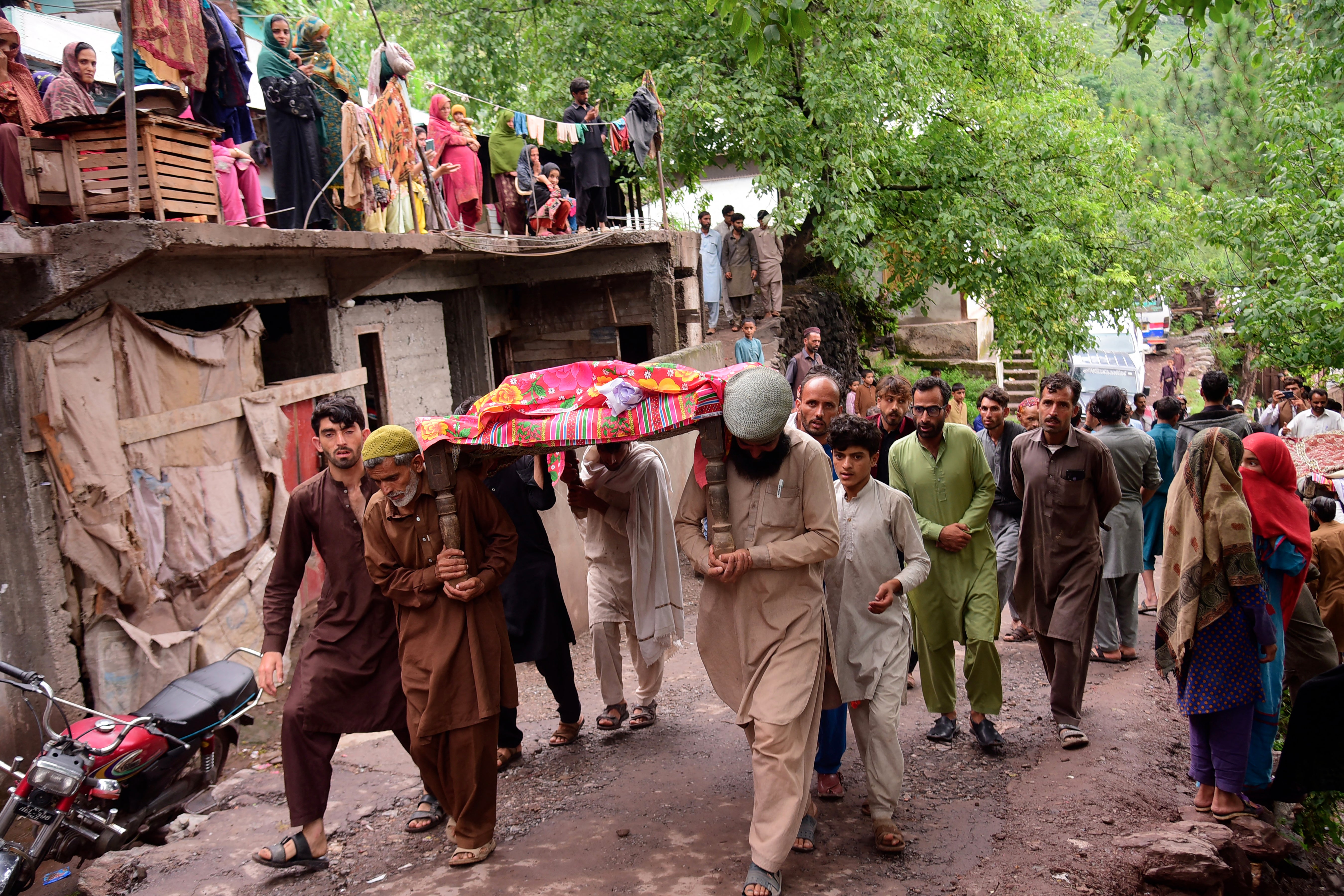 Mourners carry a coffin ofÂ a flood affected victim after flash floods in Naryean Behaak village some 36kms north from Muzaffarabad