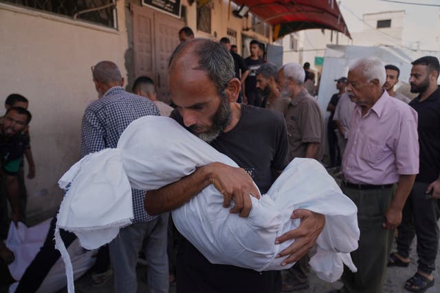 <p>Ahmed al-Hajj carries the body of his daughter, Dana, 13, who was killed in an Israeli airstrike in Gaza on Tuesday</p>
