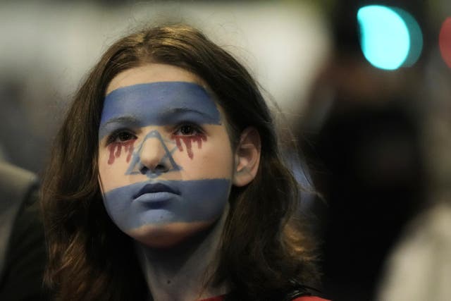 <p>A woman with her face painted with Israeli flag protest in Tel Aviv against Benjamin Netanyahu's government</p>