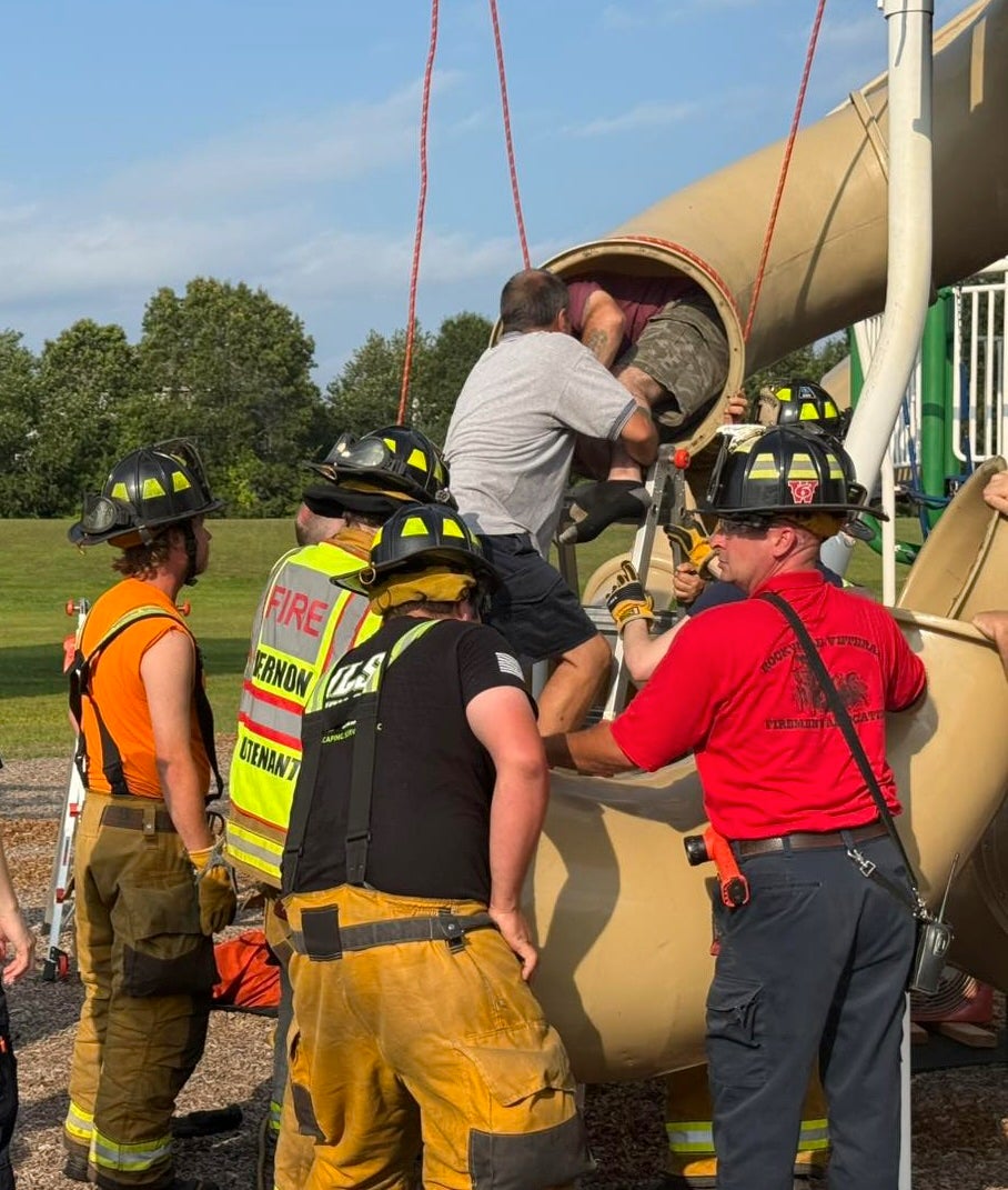 Firefighters were able to take apart the slide and free the man, who was in a fetal position, within 30 minutes