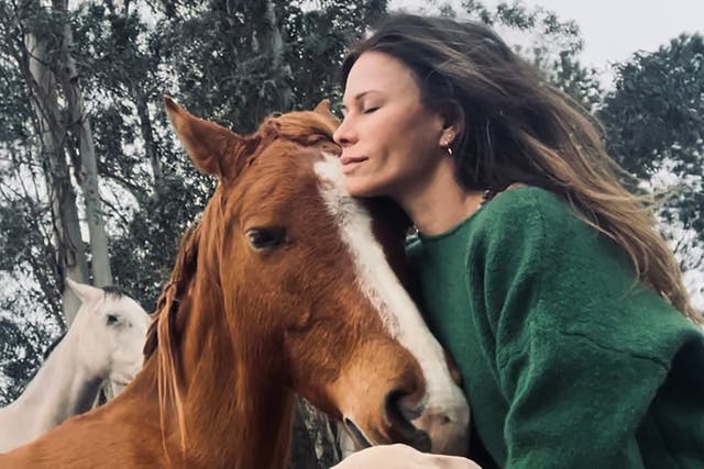 <p>The British actor Rhona Mitra with one of the horses in her sanctuary in Uruguay</p>