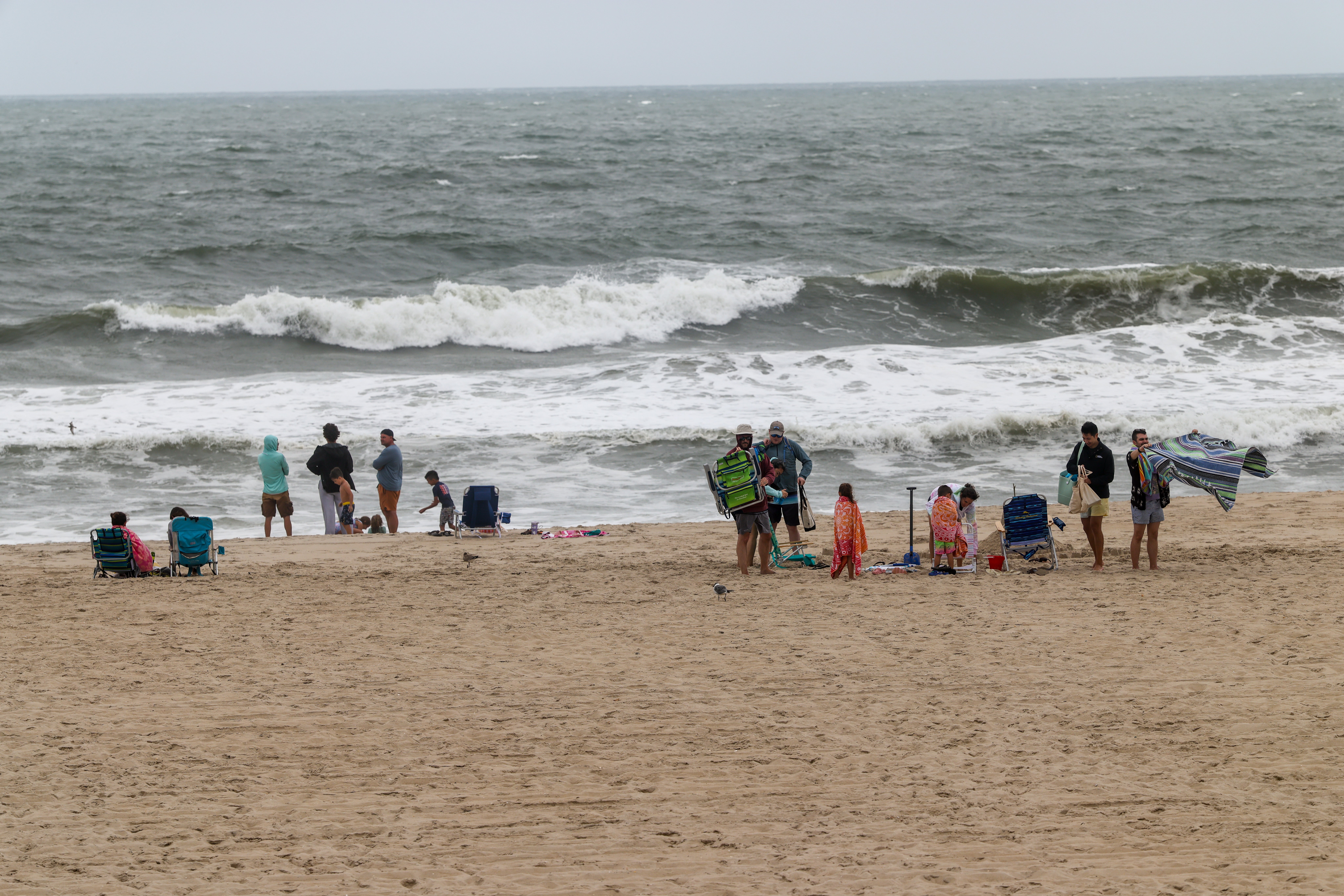 Despite no swimming being allowed, people still showed up at the beach to stand at the water's edge and watch the waves