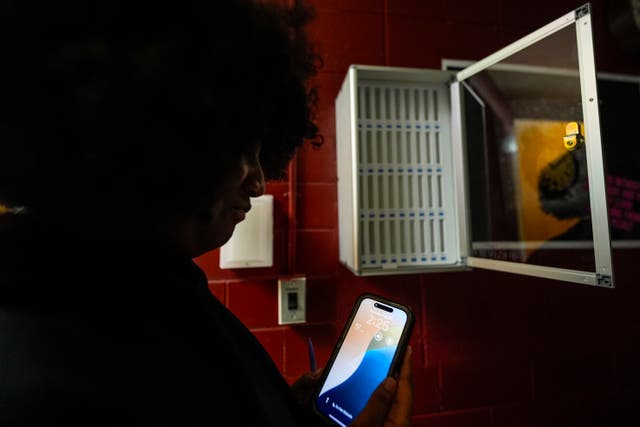 <p>Student Audreanna Johnson views her cell phone near a cell phone locker at Ronald McNair Sr. High School, Thursday, Aug. 7, 2025, in Atlanta. (AP Photo/Mike Stewart)</p>