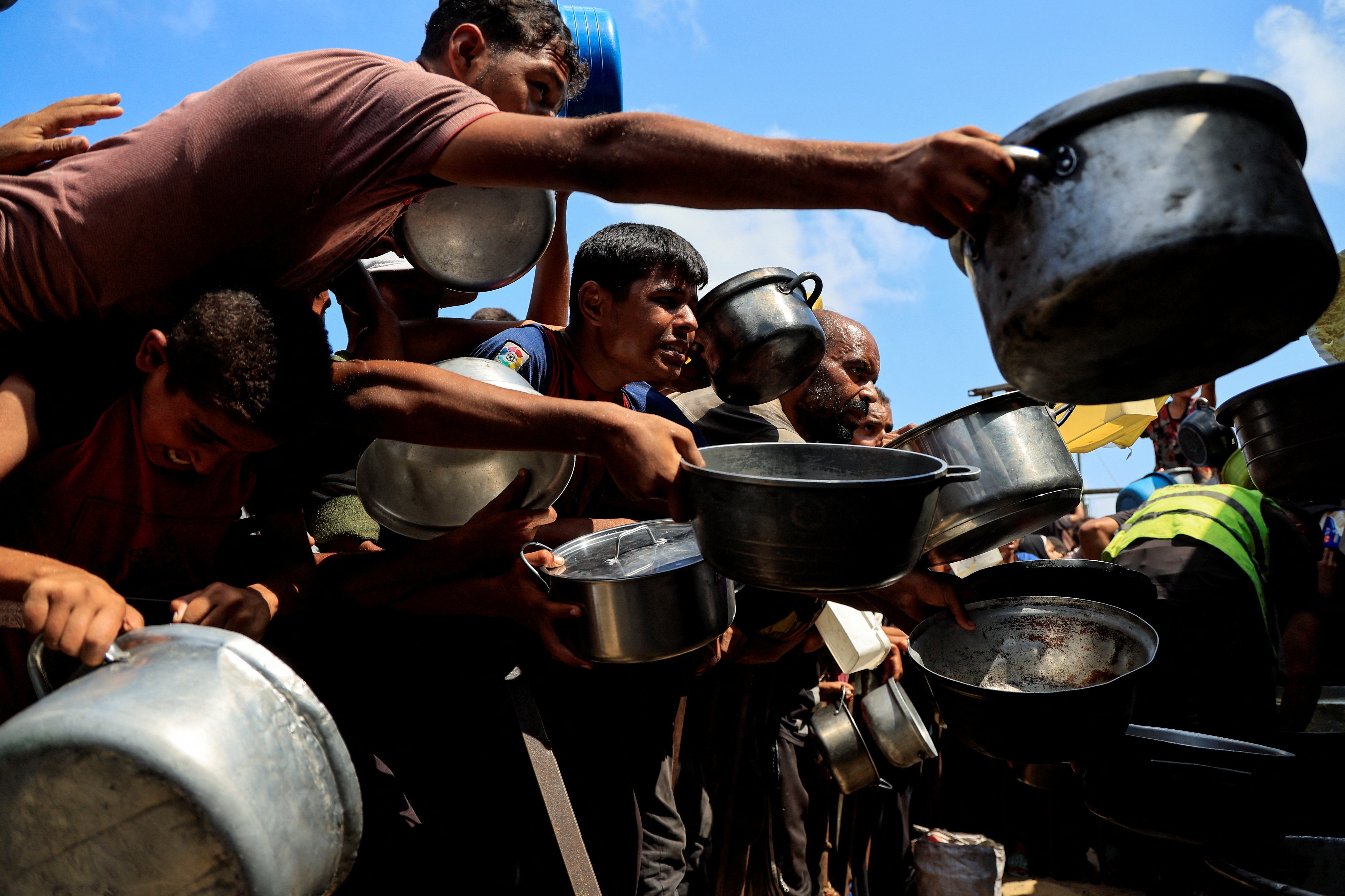 Palestinians wait to receive food as UNRWA chief says famine in Gaza is 'deliberate'