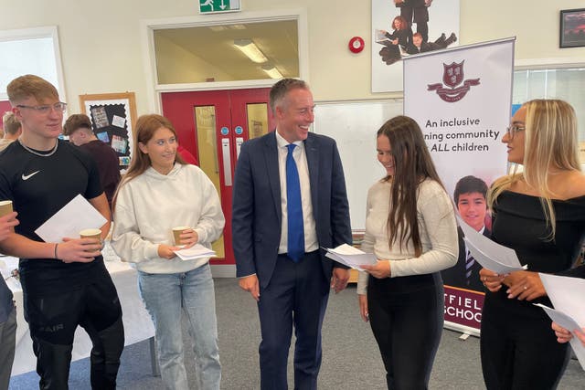 Education Minister Paul Givan (centre) congratulates students on their GCSE results at Saintfield High School in Co Down (Jonathan McCambridge/PA)