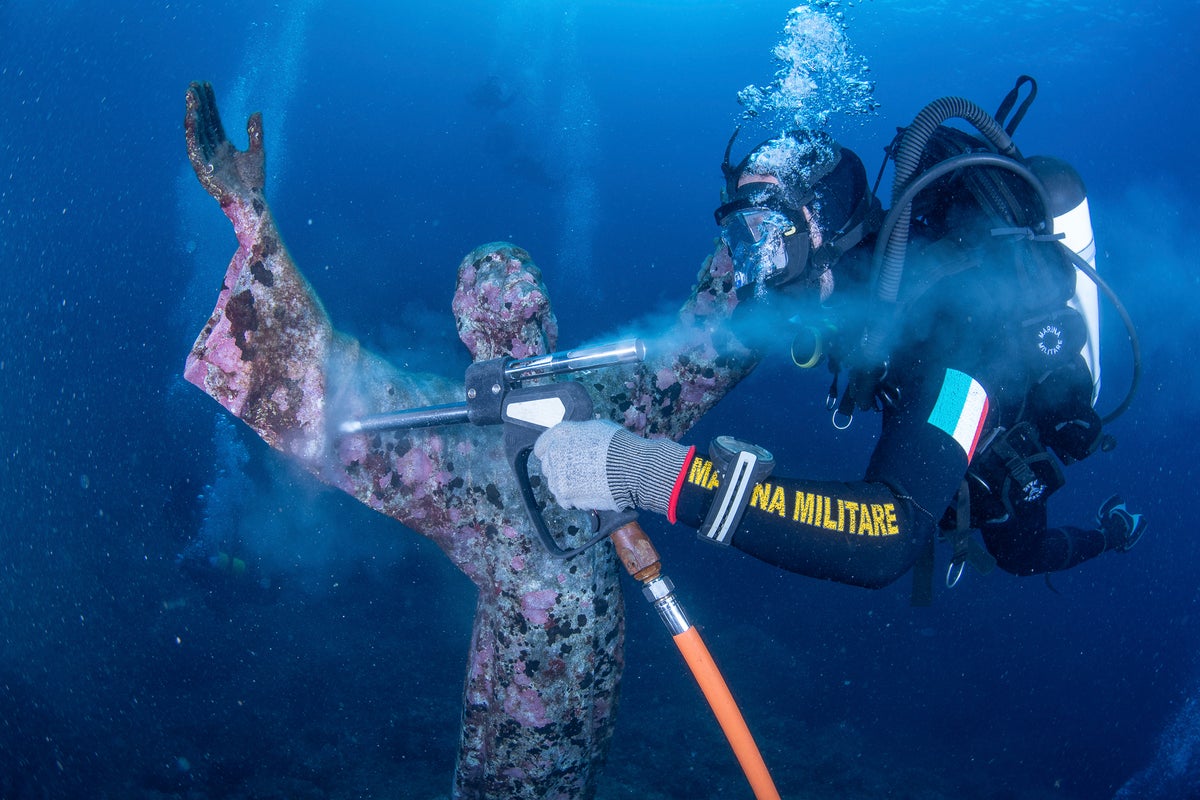Italian divers water-blast the popular underwater statue of Christ off Portofino