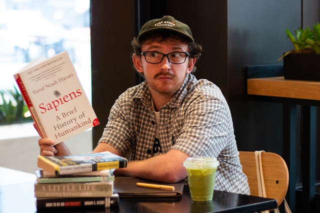 <p>The author performing as a performative male or simply enjoying a drink and a stack of good books</p>