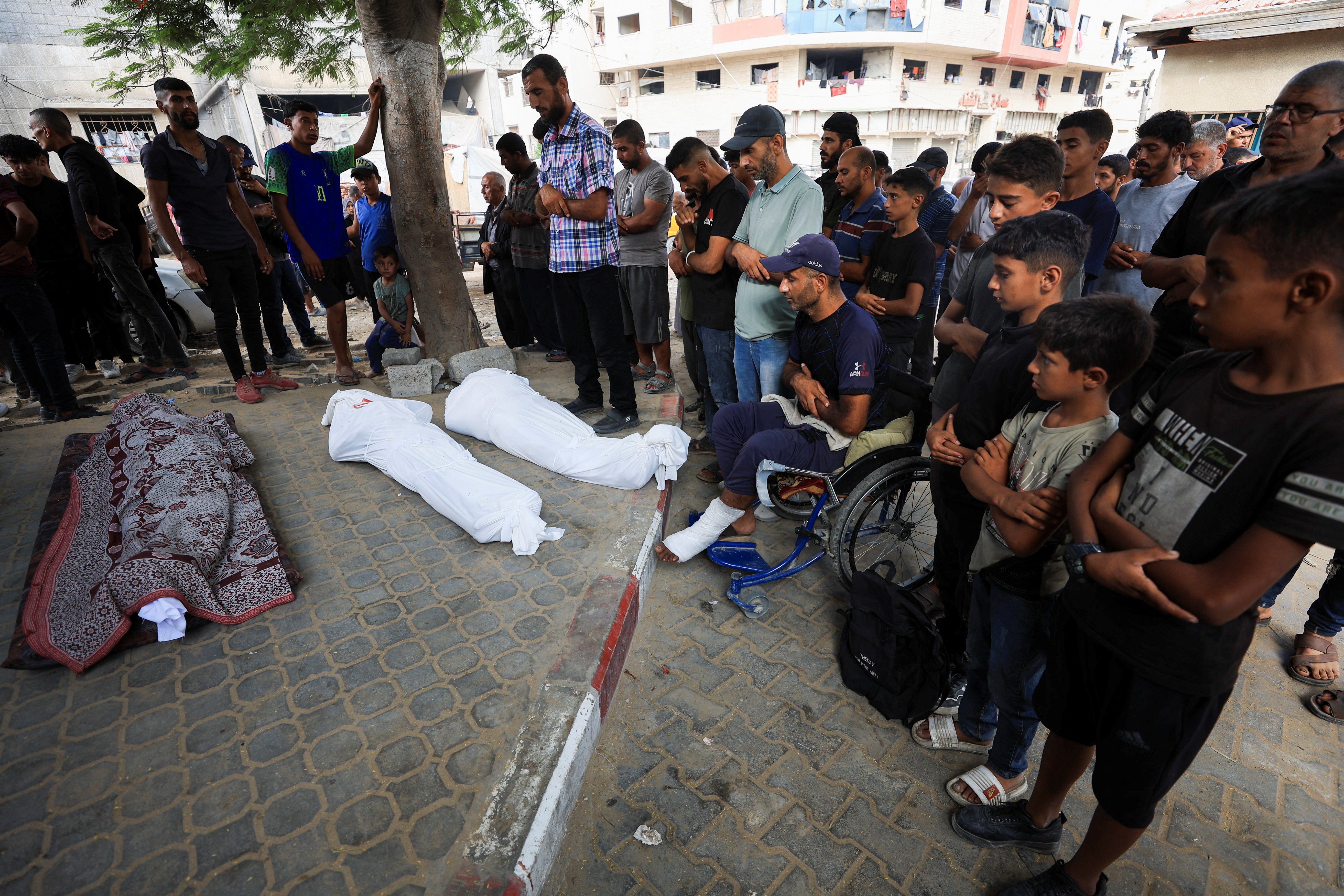 Mourners pray during the funeral of Palestinians killed by Israeli fire while trying to receive aid and others killed in Israeli strikes on Wednesday, according to medics, at Al-Shifa Hospital in Gaza City