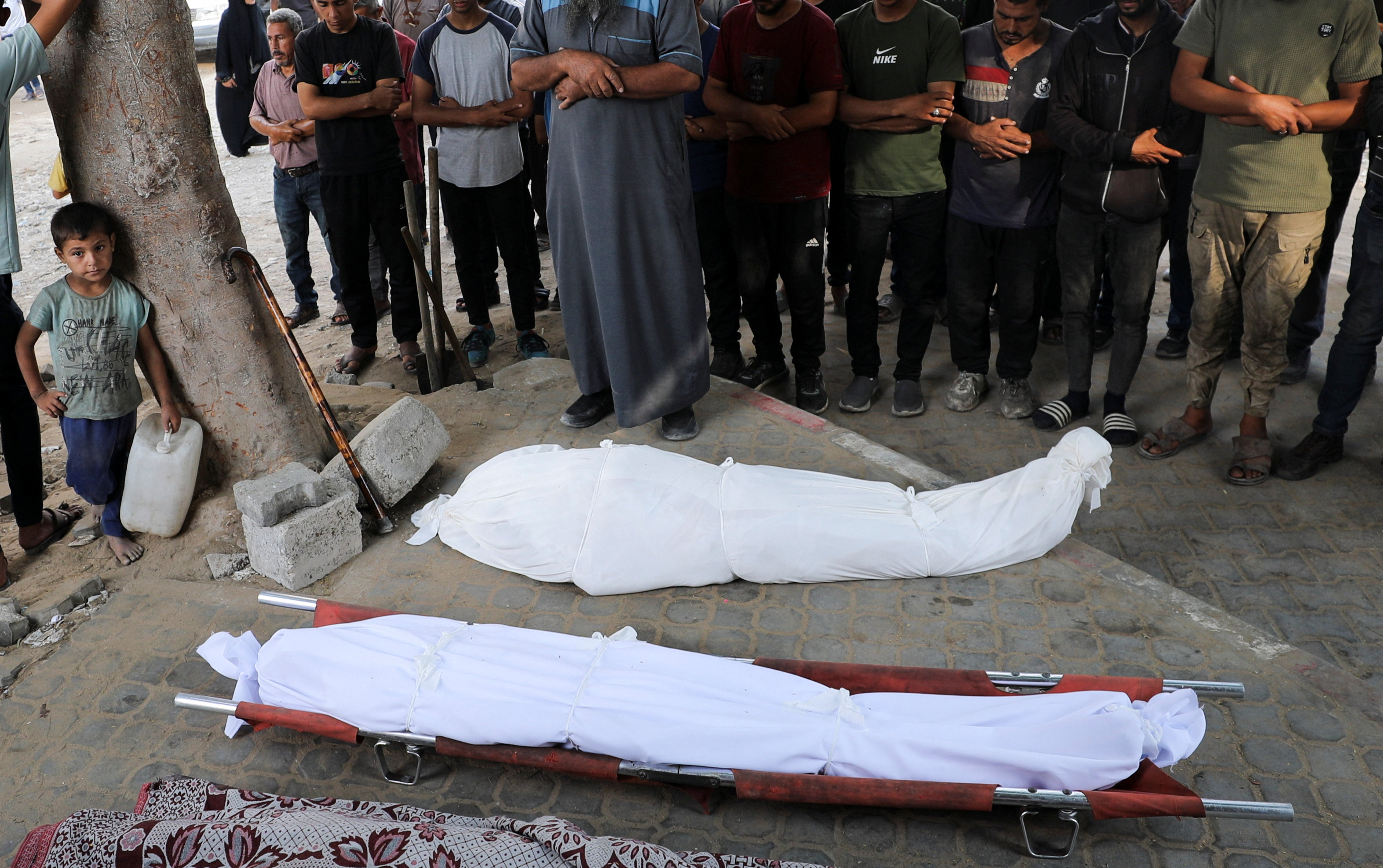Mourners pray during the funeral
